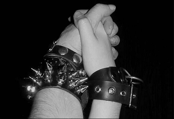 Two partners link hands to symbolise a sex-positive kink relationships