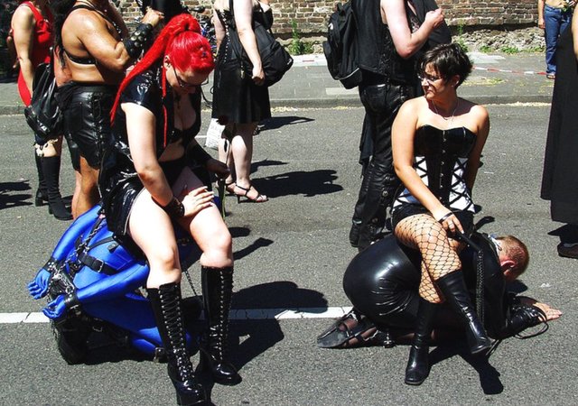 Image of two Dommes using slaves as human furniture