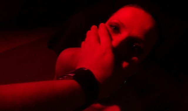 Image of submissive being held by a Dominant in a BDSM relationship