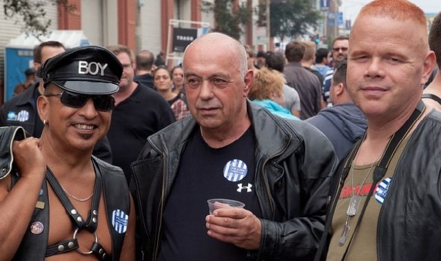 three gay leather men at a street party 