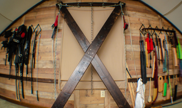 BDSM dungeon Saint Andrews's cross and impact play gear wall